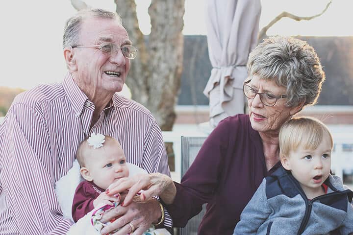 grandparents holding their grandchildren