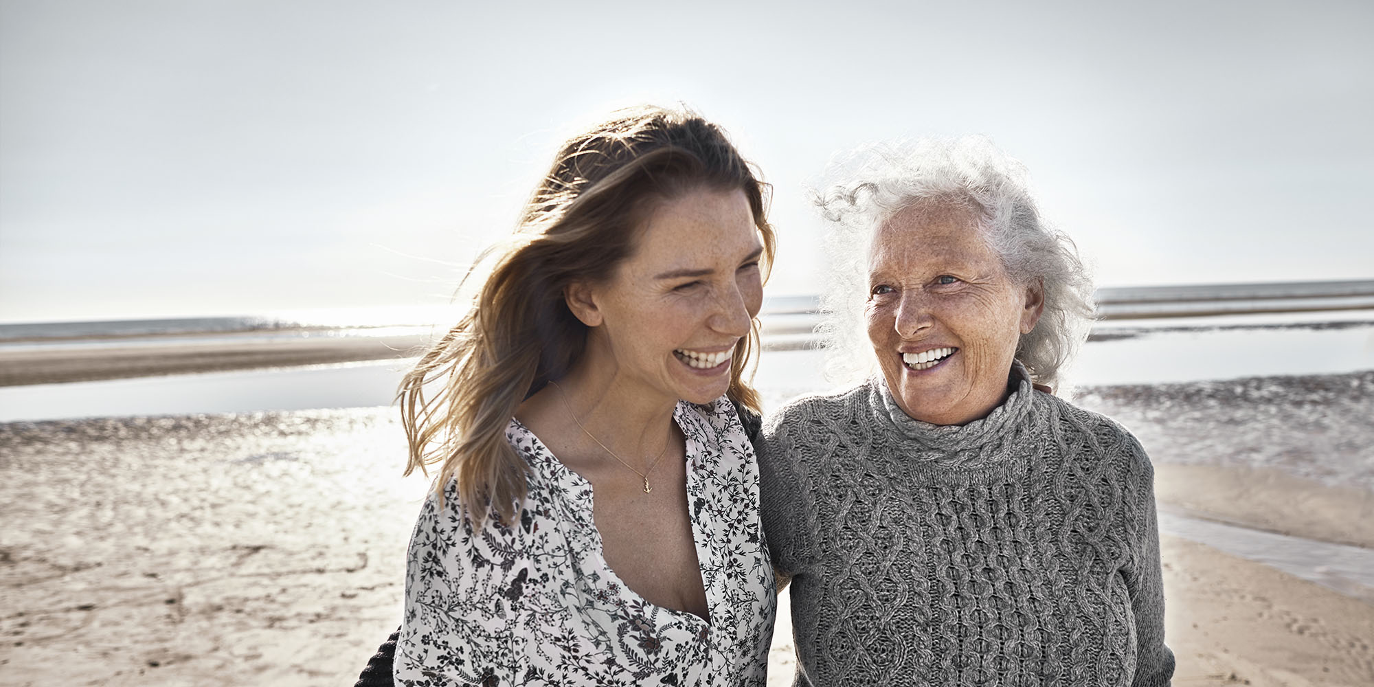 A retired mother walking on the beach with her daughter