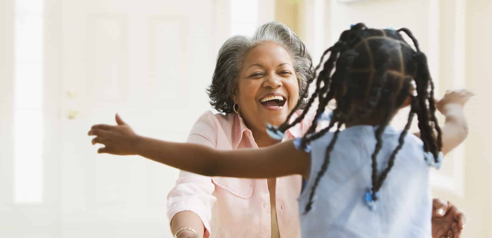 A graddaughter running to hug her grandmother