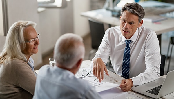 A financial professional meets with clients for their annual financial plan review