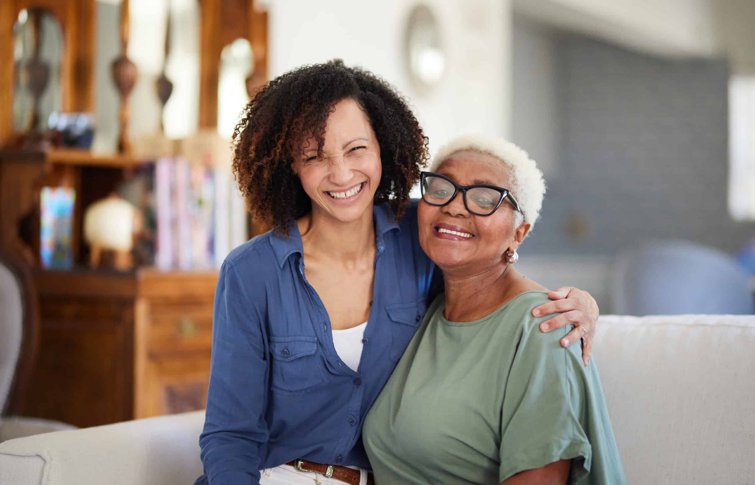 a smiling young woman embracing her older mother